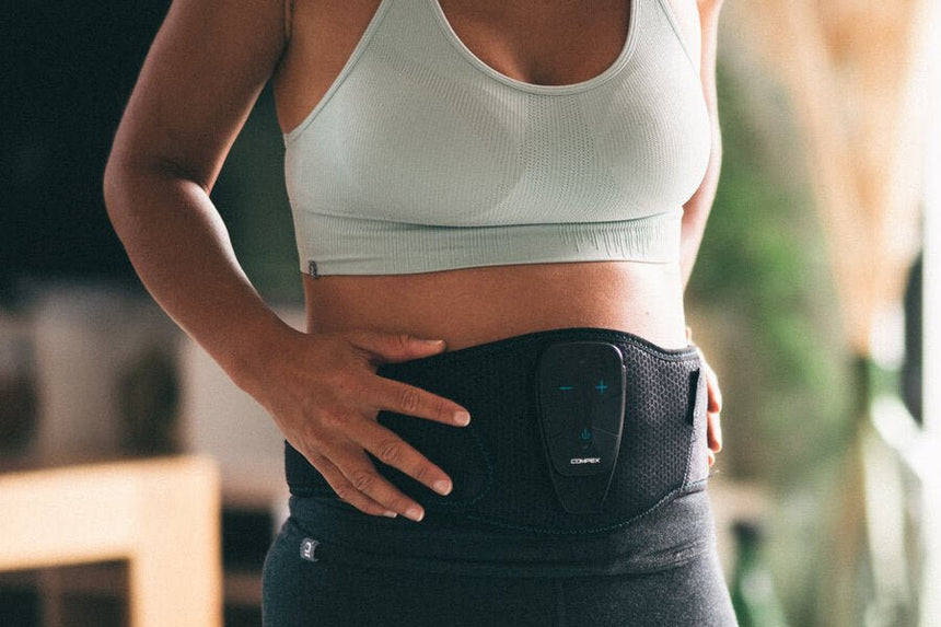 A woman using the Corebelt 5.0 to get better abs
