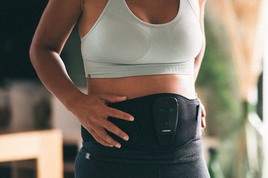 A woman using the Corebelt 5.0 to get better abs