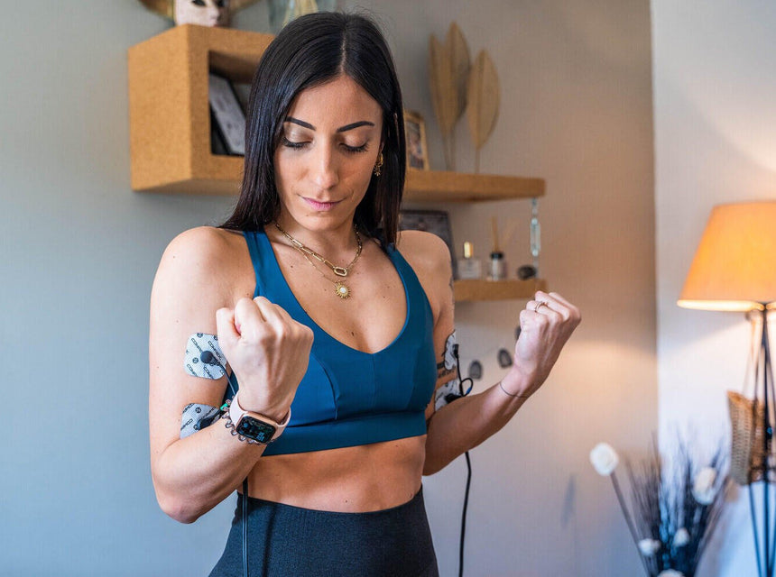 A women working to get firmer arms with the Compex FIT 3.0 muscle stimulator