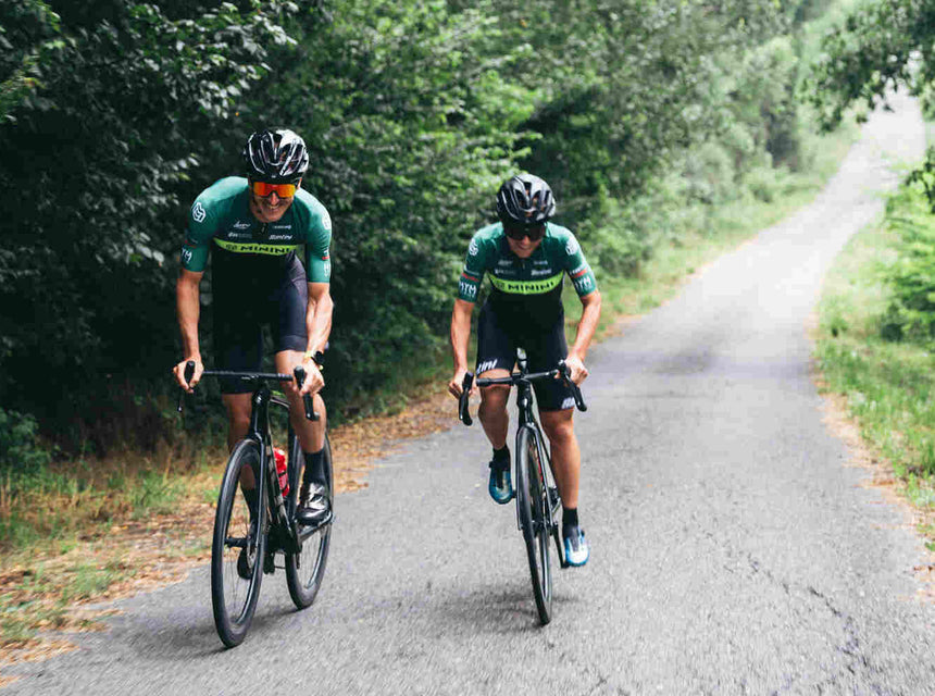 A man and a woman cycling on a road