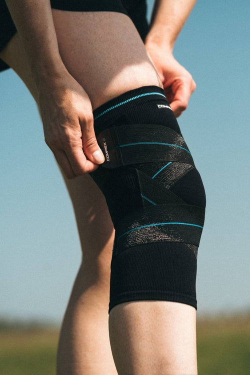 A man putting on the Compex Activ' Knee+