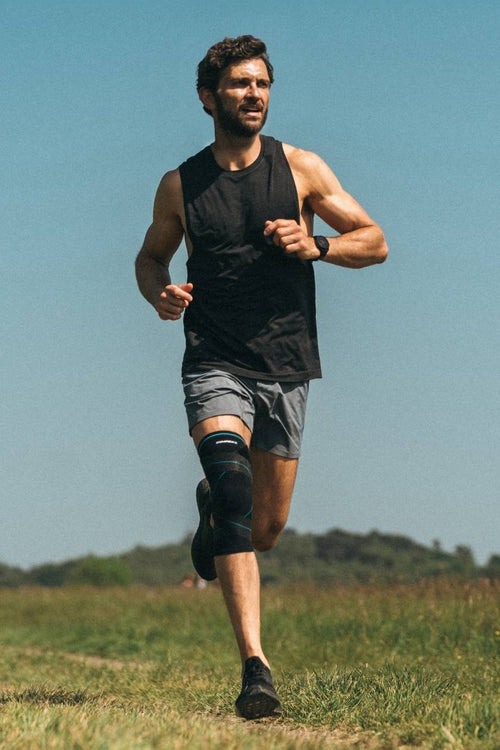 A man running wearing the Compex Activ' Knee+