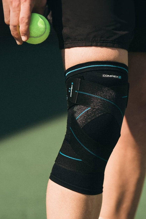 A man playing tennis wearing the Compex Activ' Knee+