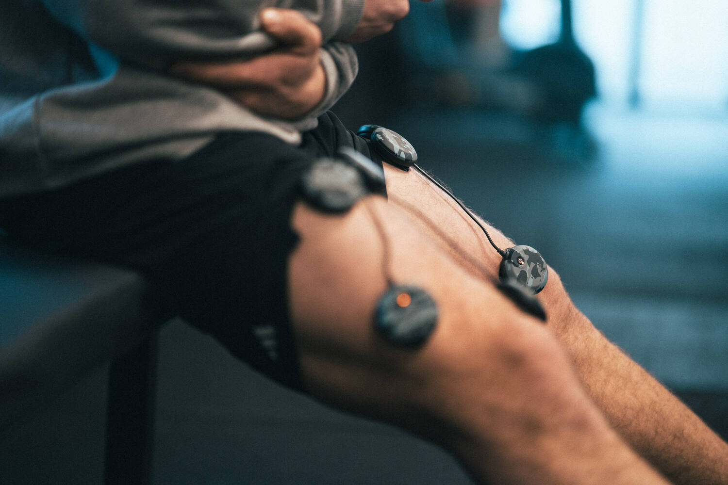 A man using a wireless Compex EMS muscle stimulator