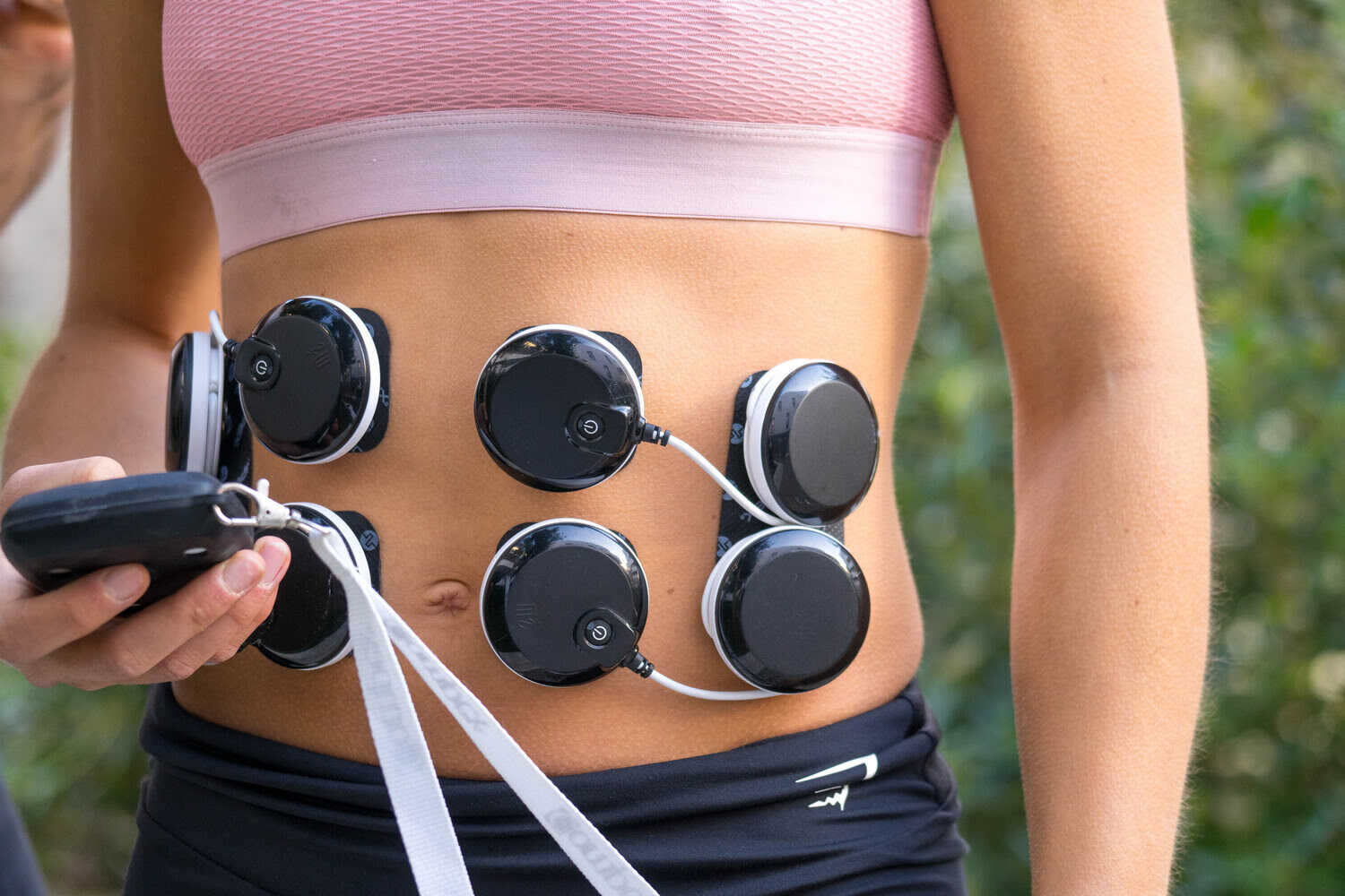 A woman exercising her glutes using the Compex FIT 5.0 muscle stimulator