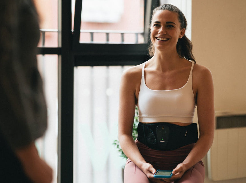 A women enjoying improving her abs using Compex Corebelt