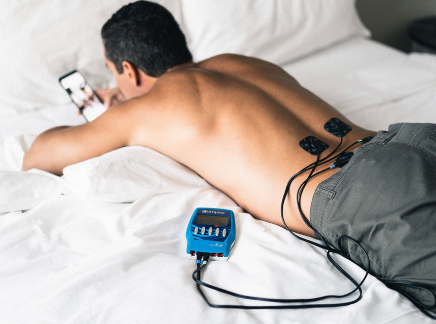 Un homme qui utilise l'électrostimulation sur son tibia