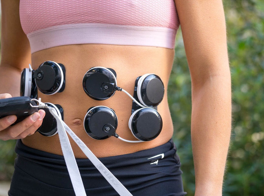 Une femme qui a les électrodes Compex sur ses abdos pour les muscler avec l'électrostimulation