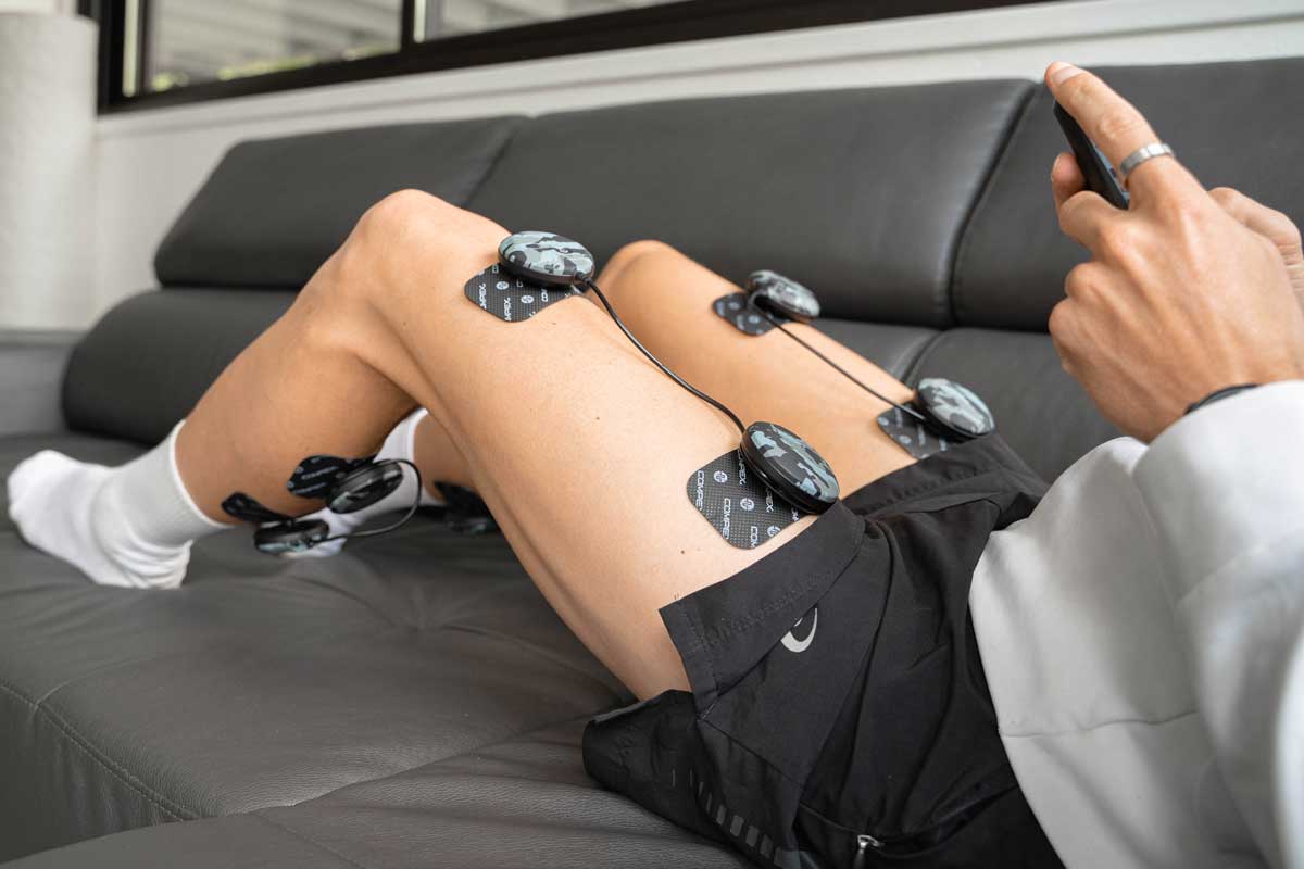 Une femme qui réaliser une séance de gainage avec l'électrostimulation compex