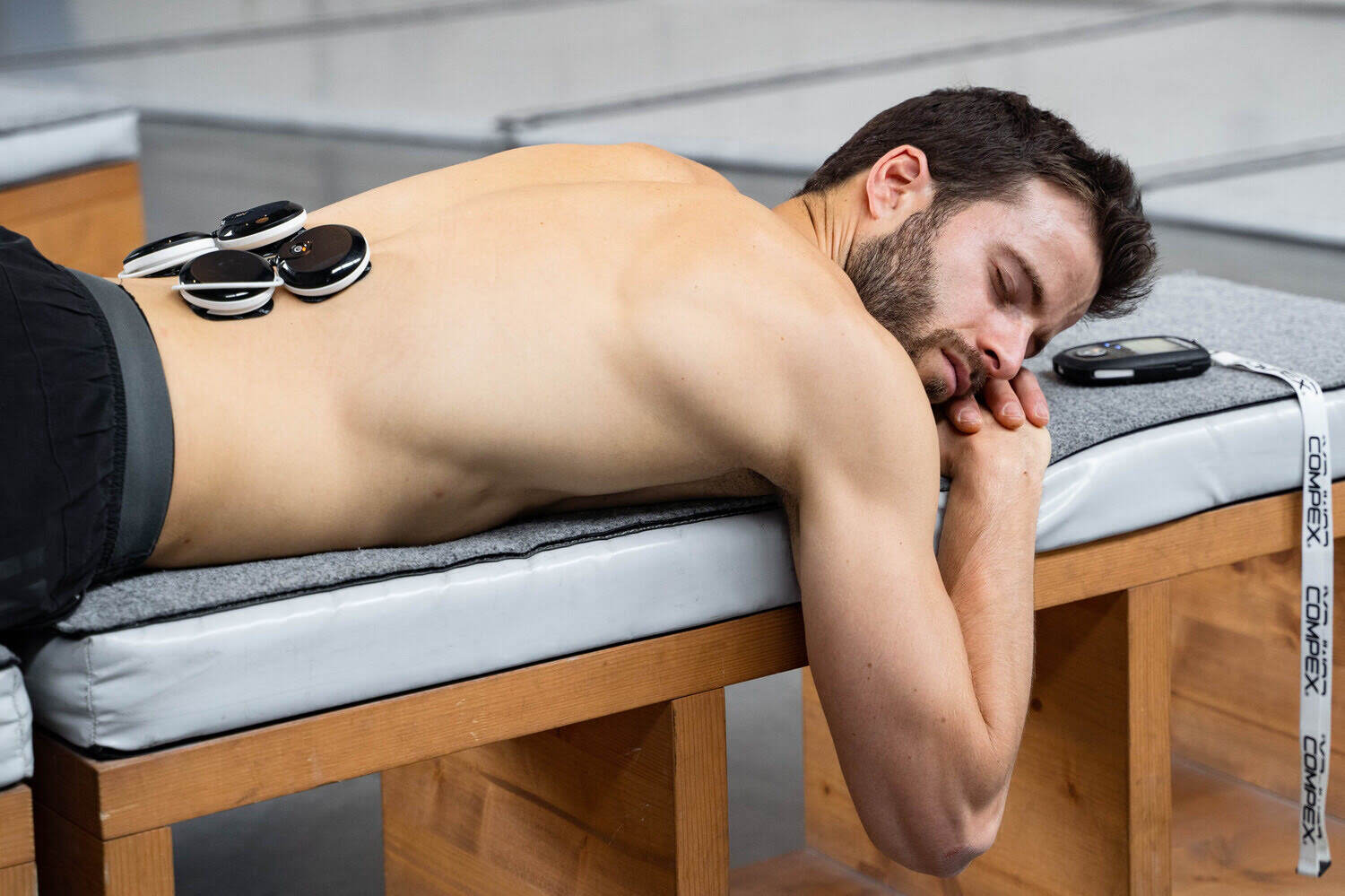 A man treating Lumbago with Compex electrostimulation