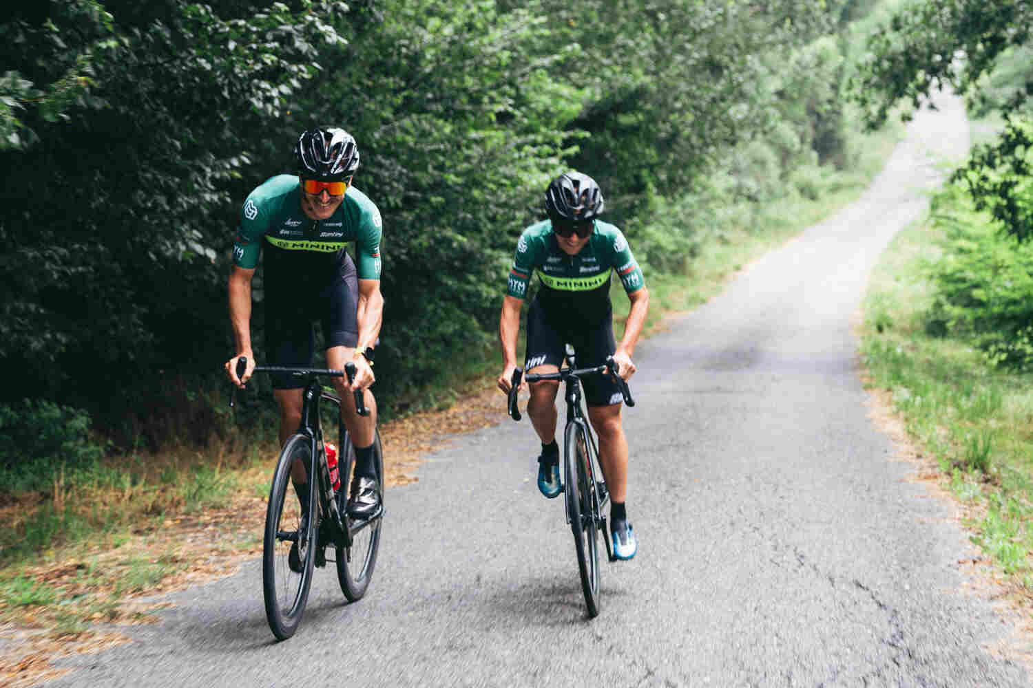 A man and a woman cycling on a road