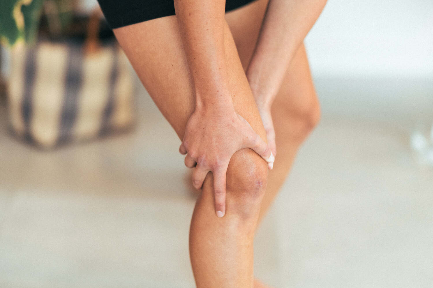 A woman holding her knee in discomfort due to joint pain