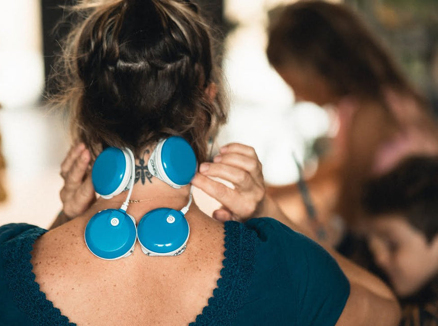 A mother using the TENS program of the FIT 5.0 muscle stimulator to treat her neck pain