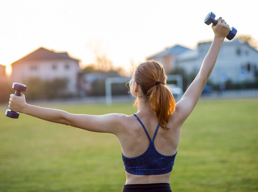 Une femme qui réalise des exercices avec des haltères pour tonifier ses épaules