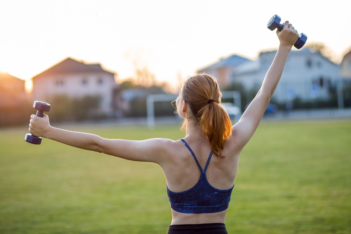 Une femme qui réalise des exercices avec des haltères pour tonifier ses épaules