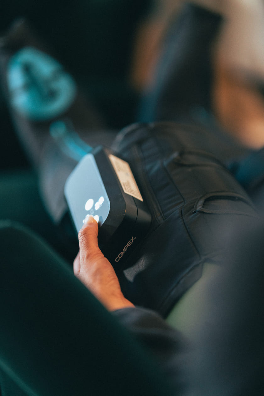 A woman using the Compex Ayre™ wireless compression boots