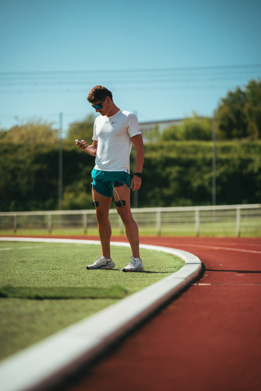 A man using the Compex SP 8.0 EMS muscle stimulator on his quads
