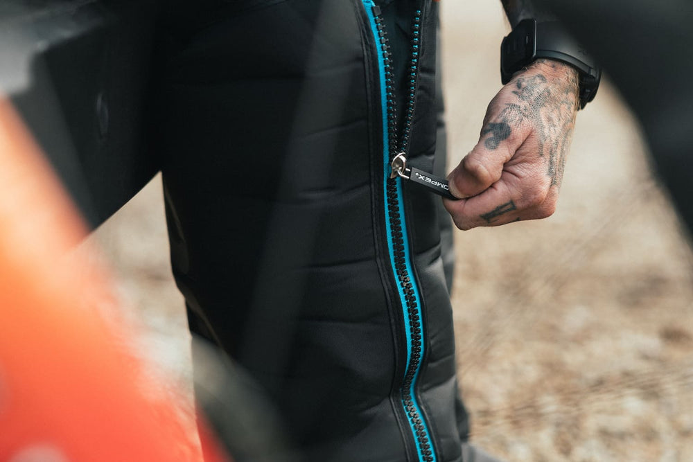 A man zipping up the Compex Ayre™ Pro compression boots