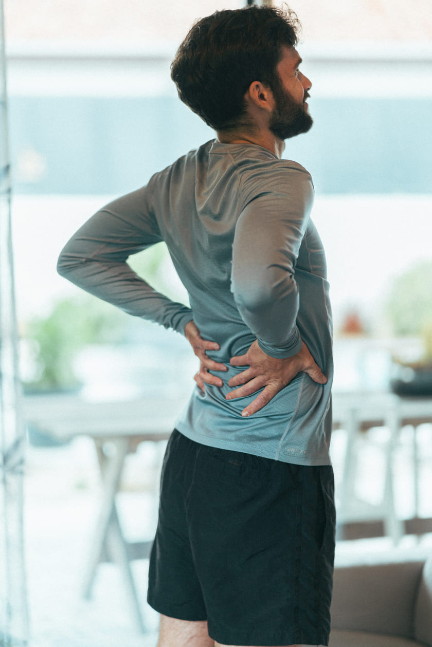 A man holding his lower back due to lower back pain