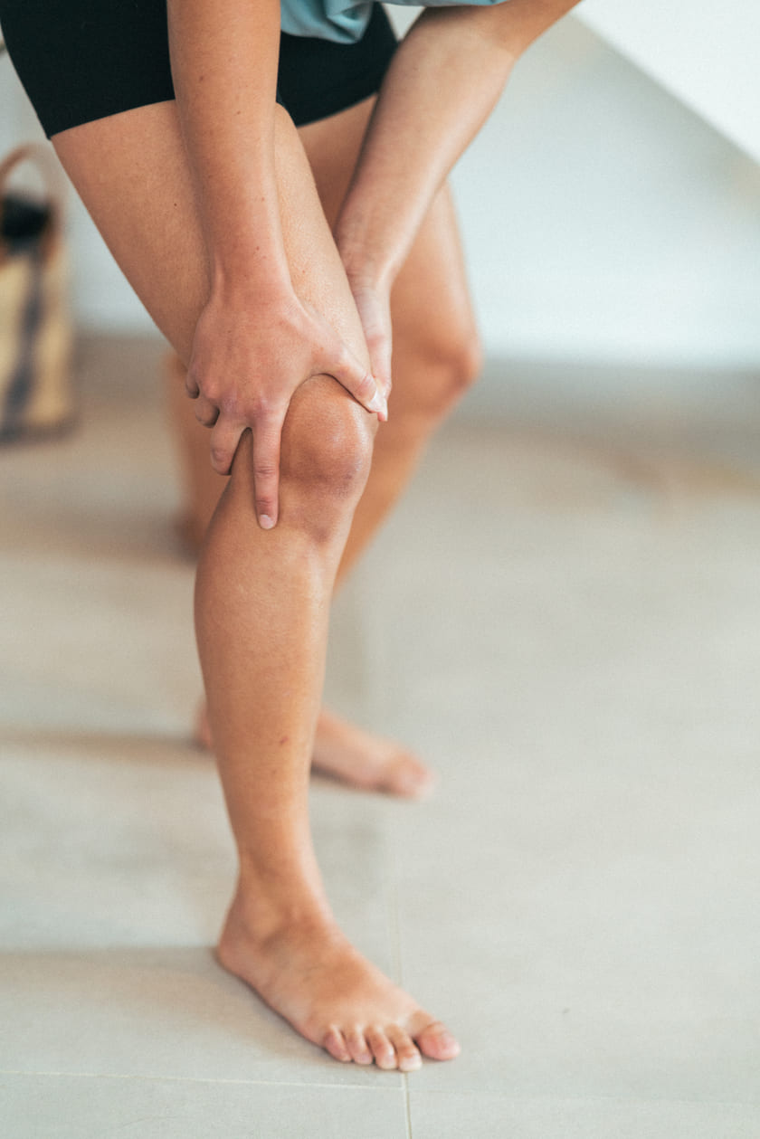 A woman holding her knee due to knee pain