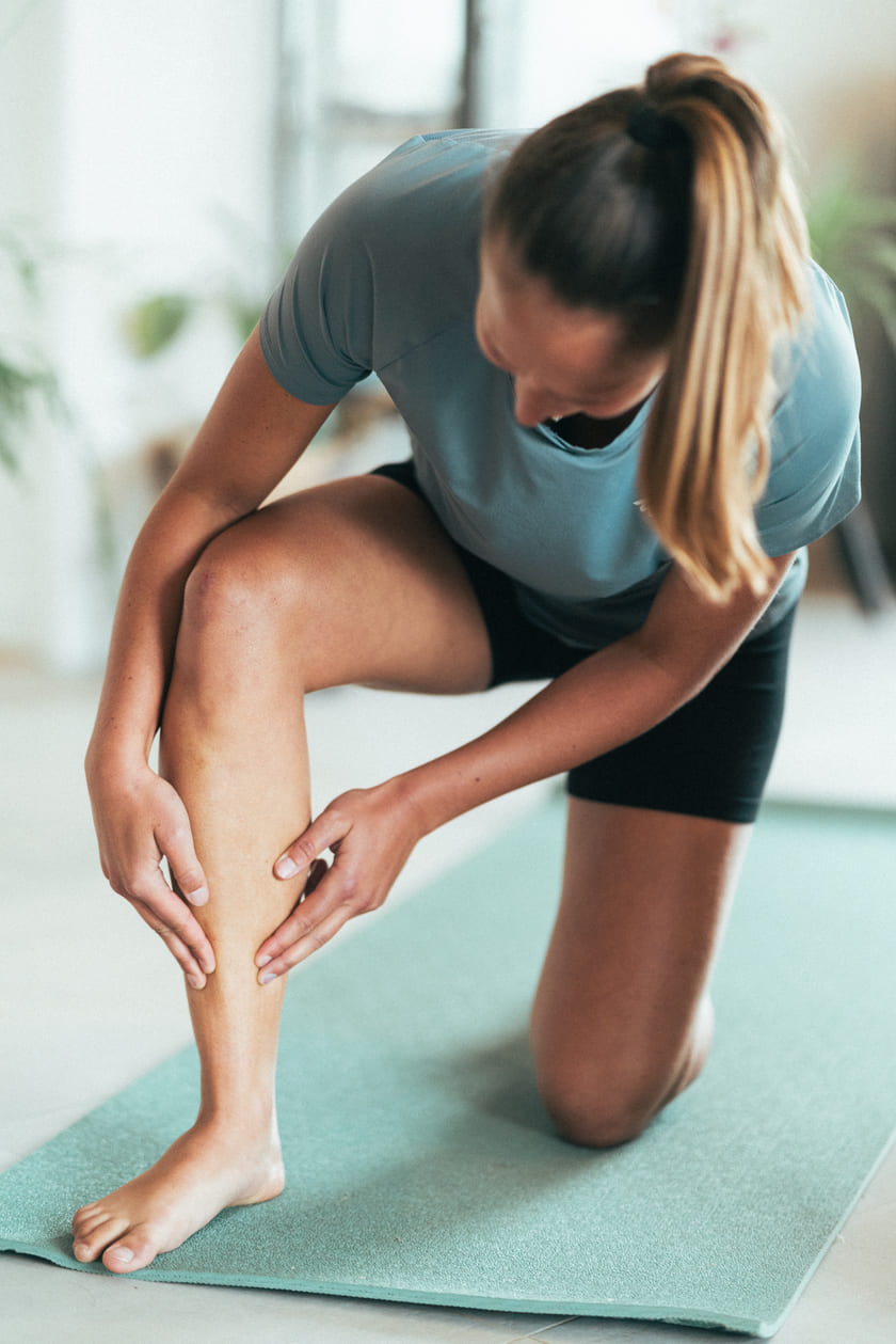 A woman holding her shin due to pain