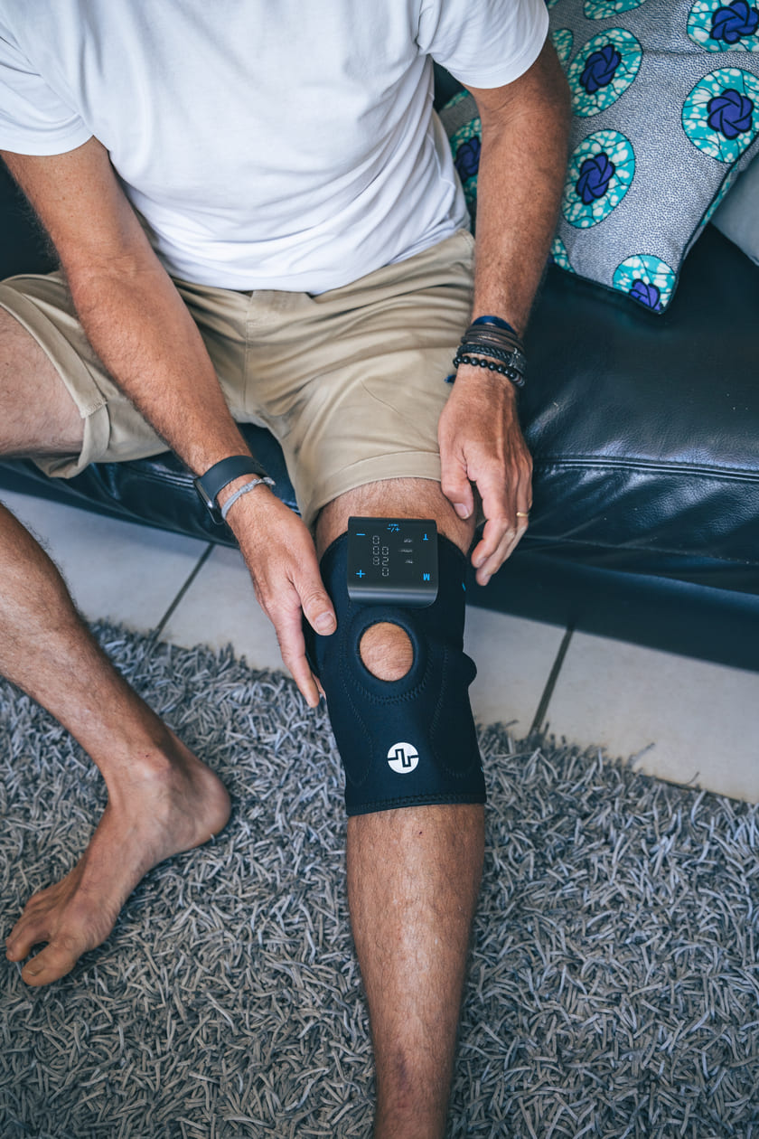 A man putting the Compex ComfortTENS Knee wrap on