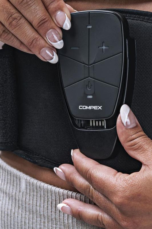 A woman putting the device into the Compex Corebelt 1.0 EMS muscle stimulator belt