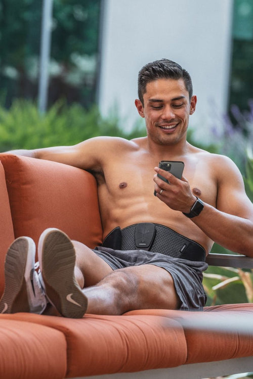 A man using the Compex Corebelt 3.0 EMS muscle stimulator belt