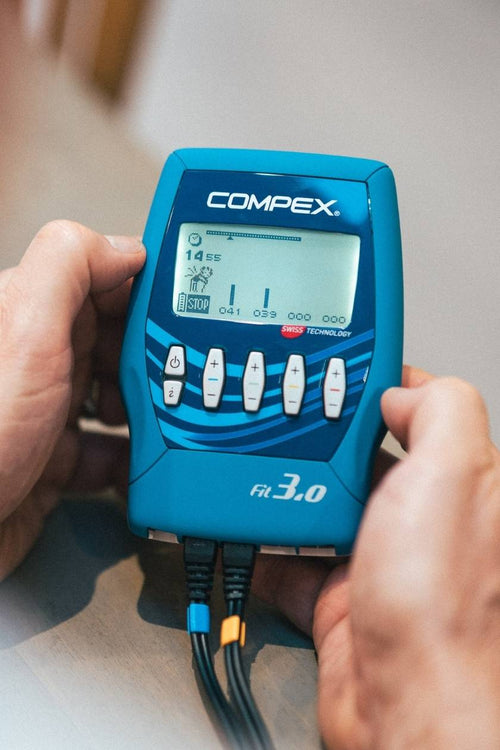 A person using the Compex FIT 3.0 EMS muscle stimulator for a pain relief session