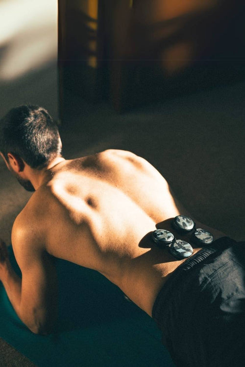 A man doing a plank using the Compex SP 8.0 WOD Edition EMS muscle stimulator for a core muscle strengthening session