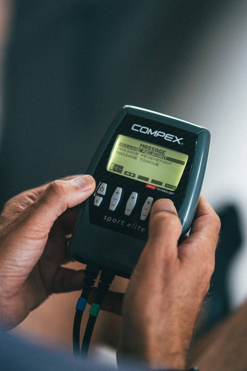 A man using the Compex Sport Elite EMS muscle stimulator for a massage