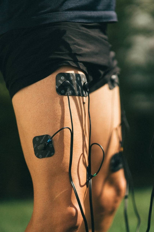 A man using the Compex Sport EMS muscle stimulator for a quad muscle strengthening session