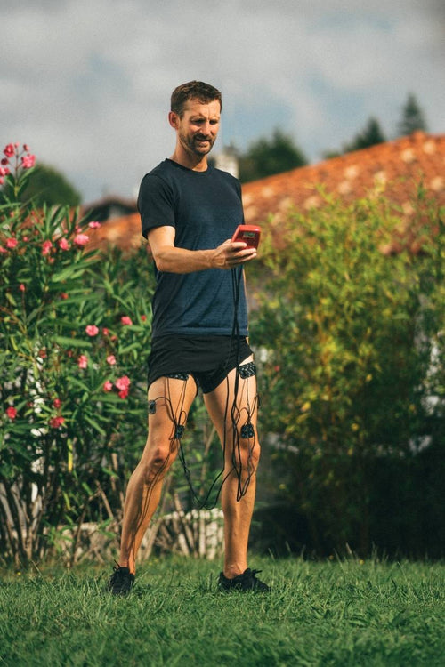 A man using the Compex Sport EMS muscle stimulator for a quad muscle strengthening session