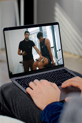 A man viewing Compex Online EMS training on his laptop
