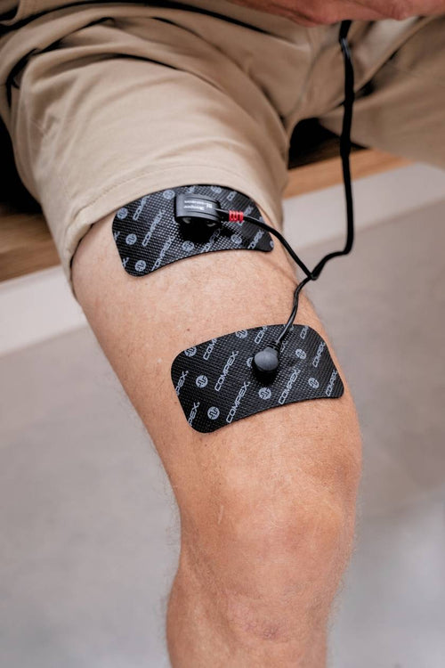 A person using the Compex Mi-Sensor on their quad muscles for personalised electrical muscle stimulation (EMS)