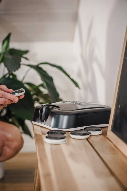 A user putting the Compex SP 8.0 EMS muscle stimulator into its docking station
