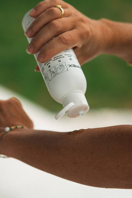 A woman applying Compex Electrode Gel to her forearm before an electrical muscle stimulation (EMS) session