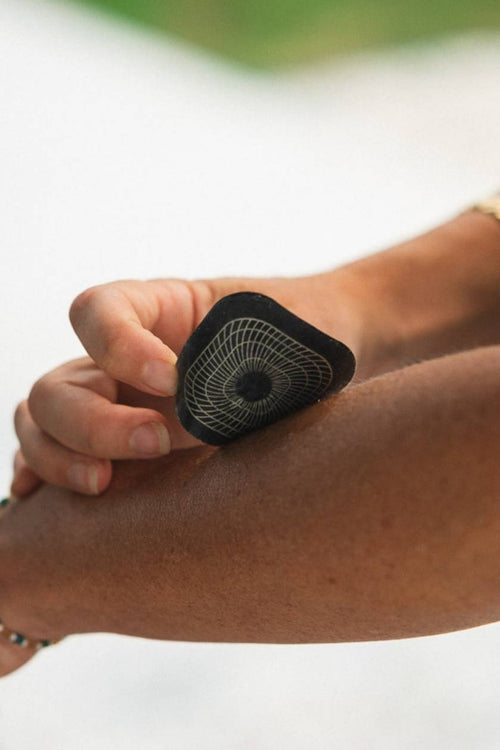 A woman placing a small Compex electrode on her forearm