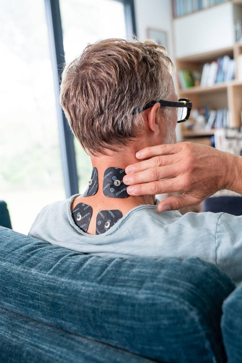 A man with four small Compex electrodes on his neck