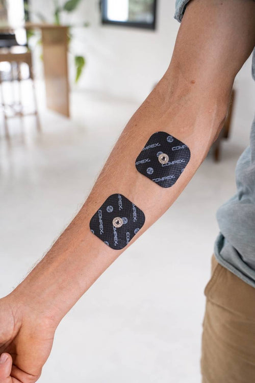 A man with two small Compex electrodes on his forearm