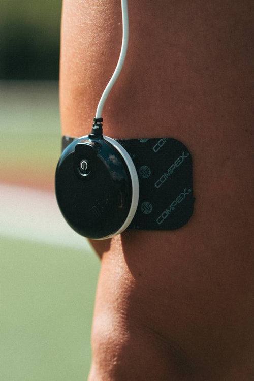 A man with the Compex SP 8.0 EMS muscle stimulator in use on his quad muscles