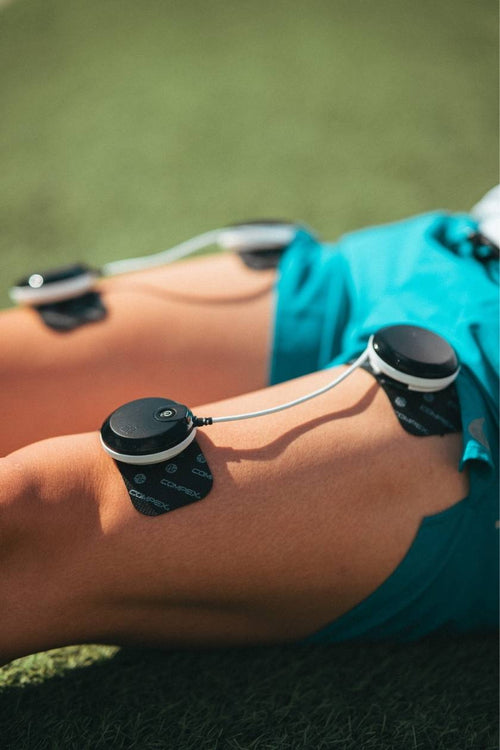 A man using the Compex SP 8.0 EMS muscle stimulator on his quad muscles for a recovery session