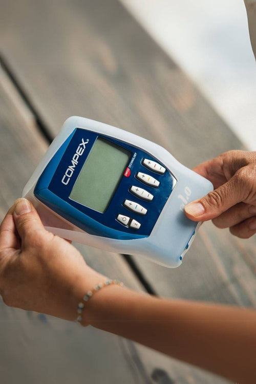 A person putting the Compex FIT 1.0 into the Protective Case for Wired EMS Muscle Stimulators