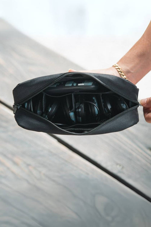 A person zipping up the Compex Travel Pouch for Wireless EMS Muscle Stimulators