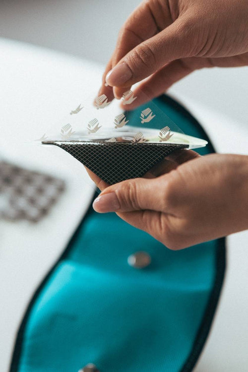 A woman peeling the plastic cover off a Compex Corebelt Electrode