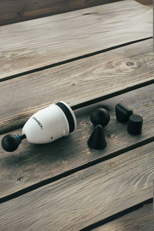 The Compex Fixx™ Mini massage gun and its additional tips on a table