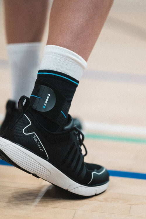 A man playing sport, wearing the Compex Activ'® Ankle+ support