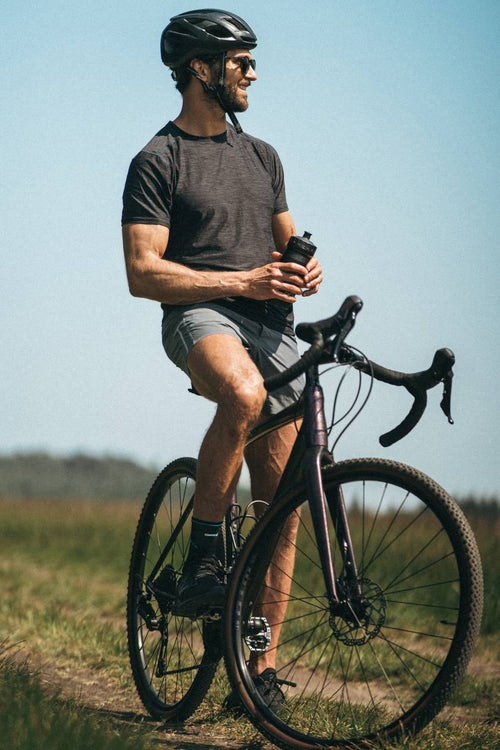 A man on a mountain bike, wearing the Compex Activ’® Ankle Support