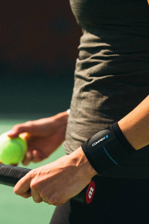 A woman playing tennis, wearing the Compex Activ'® Wrist Band+ Support