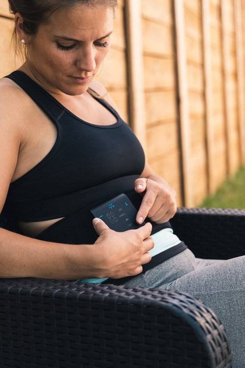 A woman using the Compex ComfortTENS Back Wrap